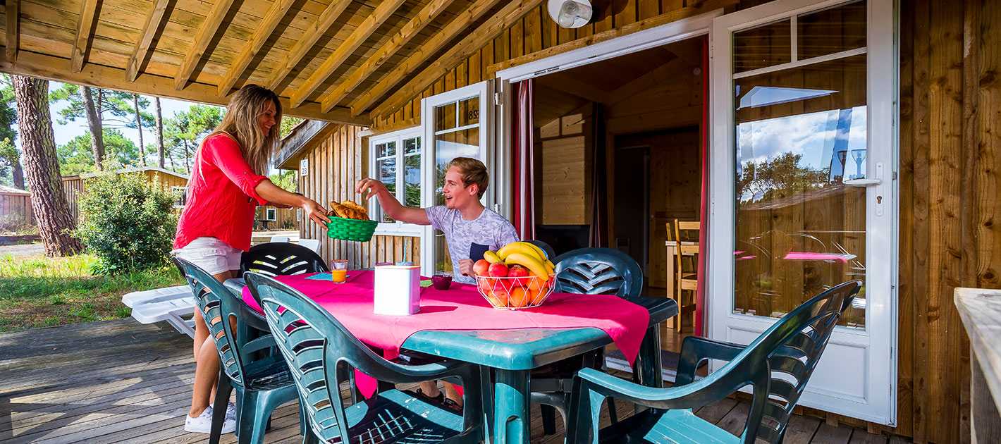 A couple's moment on the terrace of one of the accommodation at Les Embruns campsite