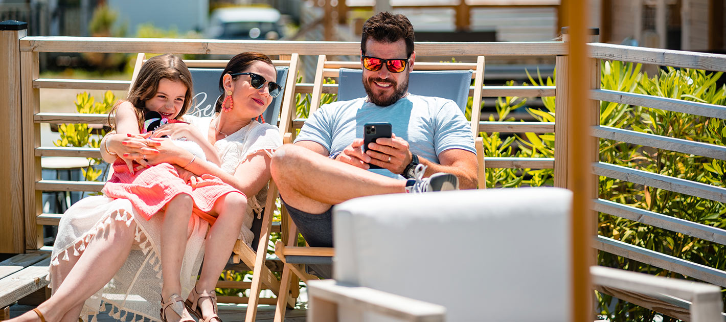 Famille sur des transats sur une terrasse de mobil home