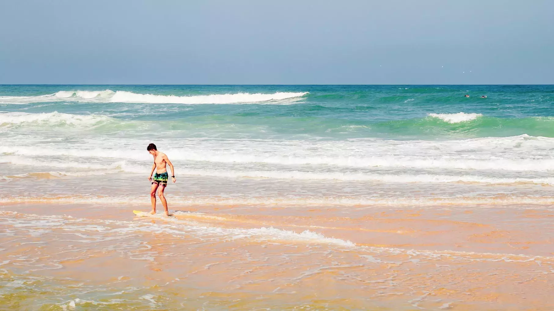 un enfant s'amuse à glisser sur les vagues