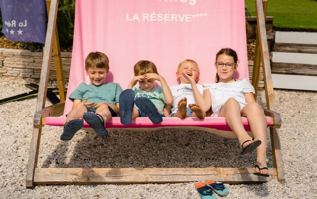 Enfants sur une maxi chaise longue au camping La Réserve