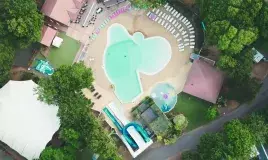 Vue aérienne de la piscine et de l'espace aquatique du camping Siblu Villages Les Pierres Couchées