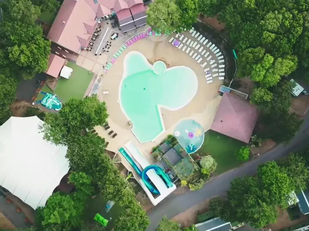 Vue aérienne de la piscine et de l'espace aquatique du camping Siblu Villages Les Pierres Couchées