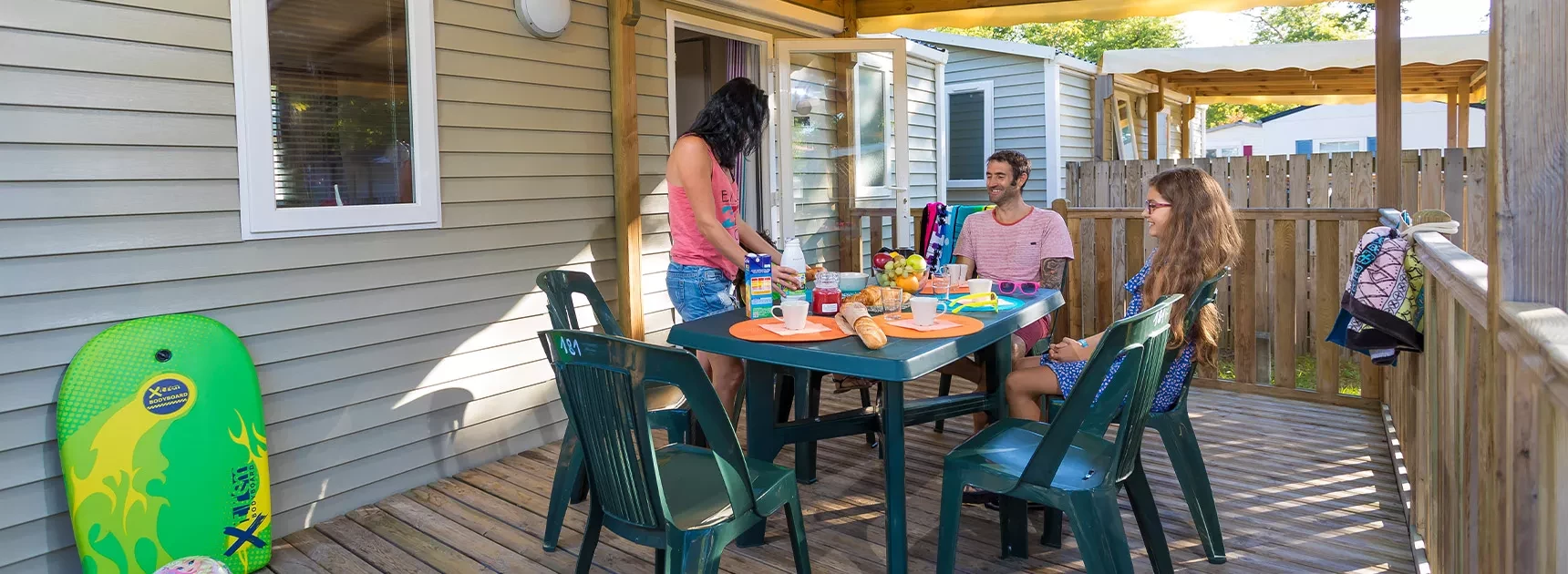 Famiille sur la terrasse de son mobil home camping Les Embruns