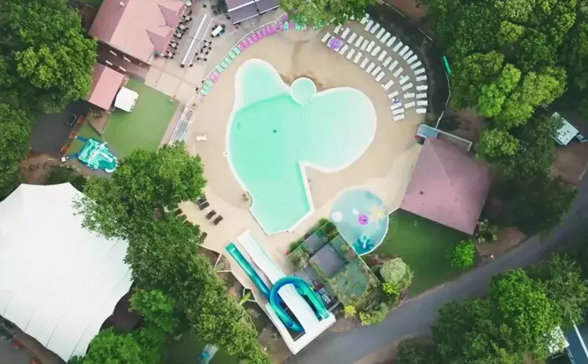 Vue aérienne de la piscine et de l'espace aquatique du camping Siblu Villages Les Pierres Couchées